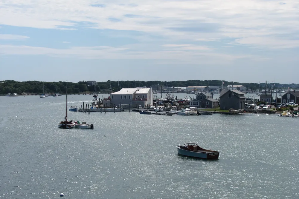 Westport Point village and harbor seen across the Westport River, with moored boats on the water