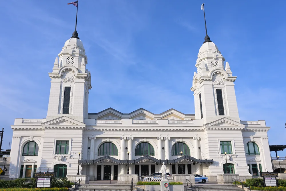 Worcester Union Station, a white Beaux-Arts train station with twin domed towers and arched green windows, under a clear blue morning sky